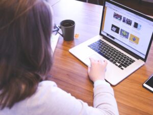 Woman browsing a website on a laptop, highlighting research and evaluation as part of a content audit process.