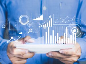 Business professional analysing data on a tablet with futuristic graphs, representing the importance of a content audit.