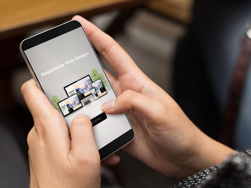 Person holding phone with responsive cafe website ideas displayed on screen in 2025.